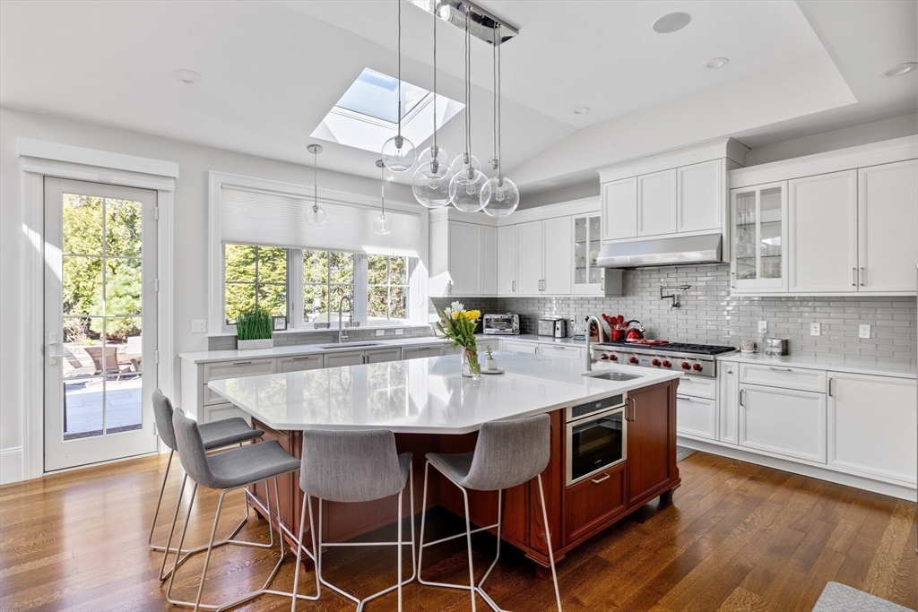 37 Radcliff Road Newton, MA 02468 - Photo 3 of 40 a kitchen with stainless steel appliances granite countertop a stove a sink dishwasher a stove a dining table and chairs with wooden floor