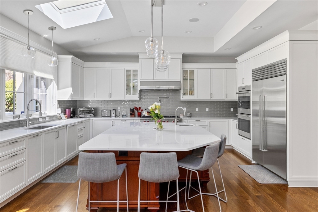 37 Radcliff Road Newton, MA 02468 - Photo 8 of 40 a kitchen with stainless steel appliances granite countertop a dining table chairs refrigerator and microwave