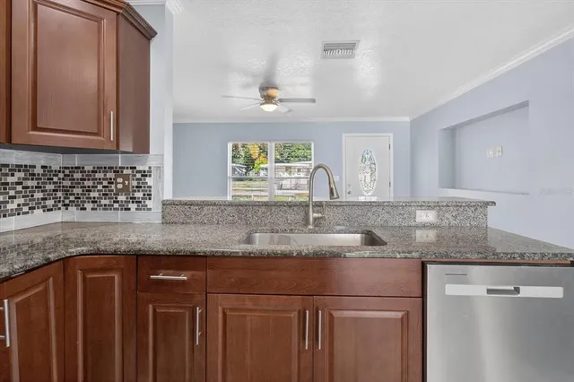 a kitchen with stainless steel appliances granite countertop a stove microwave and sink