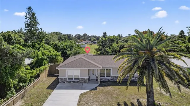 a front view of a house with a yard and potted plants