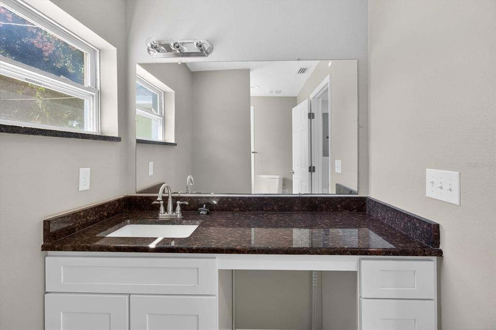 5352 Tangerine Drive New Port Richey, FL 34652 - Photo 37 of 76 a bathroom with a granite countertop sink and a mirror