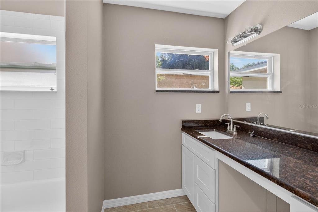 5352 Tangerine Drive New Port Richey, FL 34652 - Photo 38 of 76 a bathroom with a granite countertop sink and a mirror