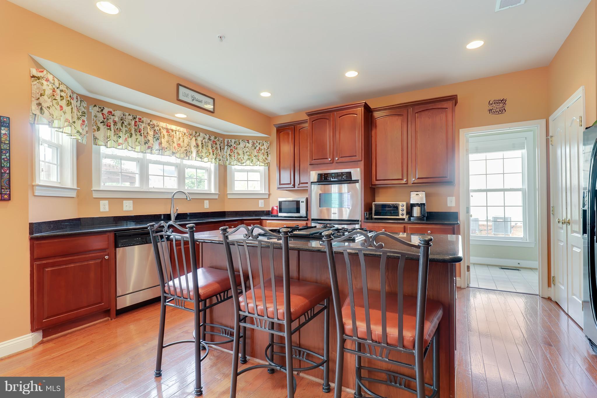 6905 Ironbridge Lane Laurel, MD 20707 - Photo 8 of 30 a kitchen with stainless steel appliances granite countertop a stove a sink and a refrigerator