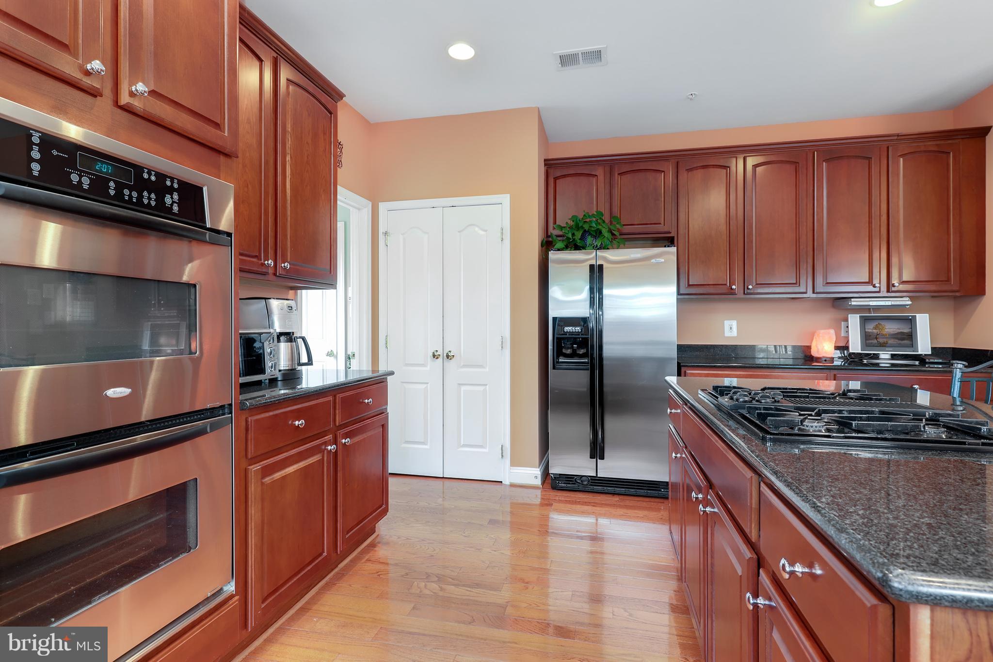 6905 Ironbridge Lane Laurel, MD 20707 - Photo 9 of 30 a kitchen with stainless steel appliances granite countertop a stove a refrigerator and a sink