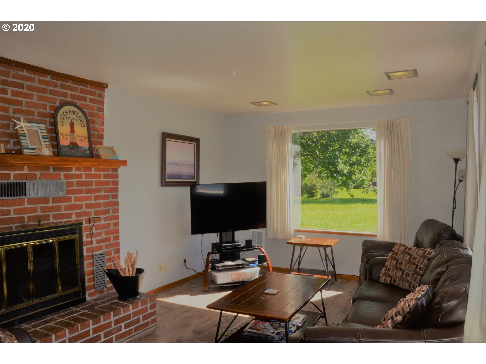 8040 Highway 126 Florence, OR 97439 - Photo 3 of 27 a living room with furniture a fireplace and a flat screen tv