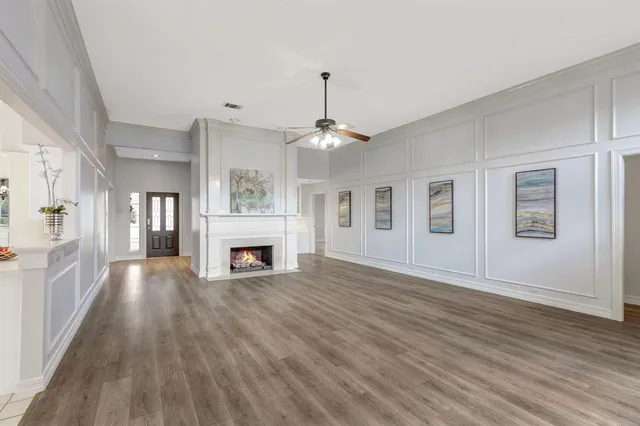 a view of a livingroom with a fireplace wooden floor and windows