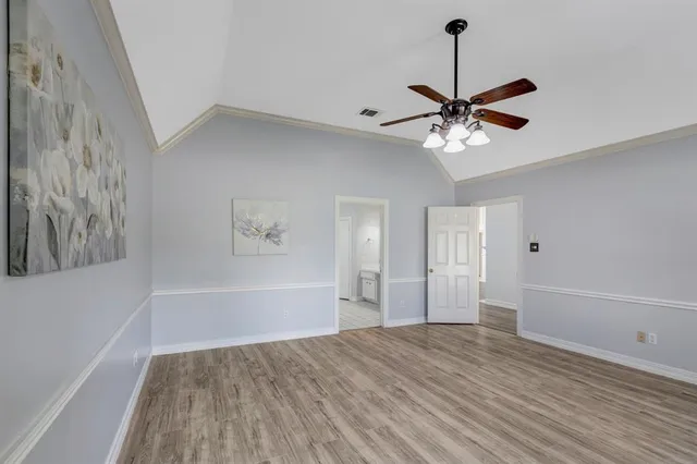 a view of an empty room with a window and a ceiling fan
