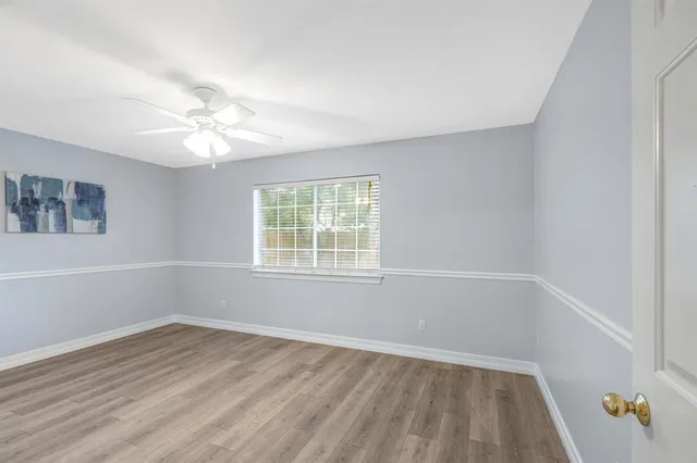 an empty room with a window and a ceiling fan