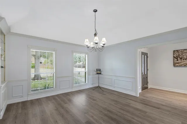 a view of a room with wooden floors and chandelier