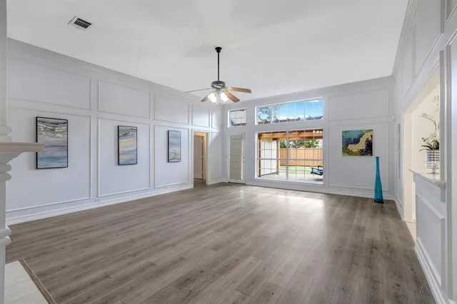 a view of an empty room with window and wooden floor