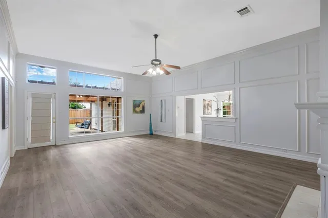 a view of an empty room with window and wooden floor