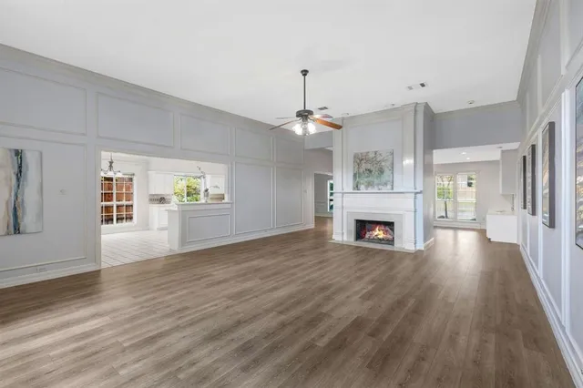 a view of a big room with wooden floor a fireplace and windows