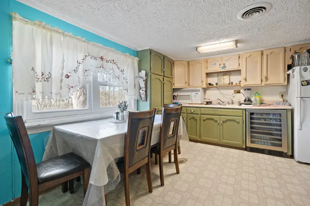 a kitchen with a table chairs sink and cabinets