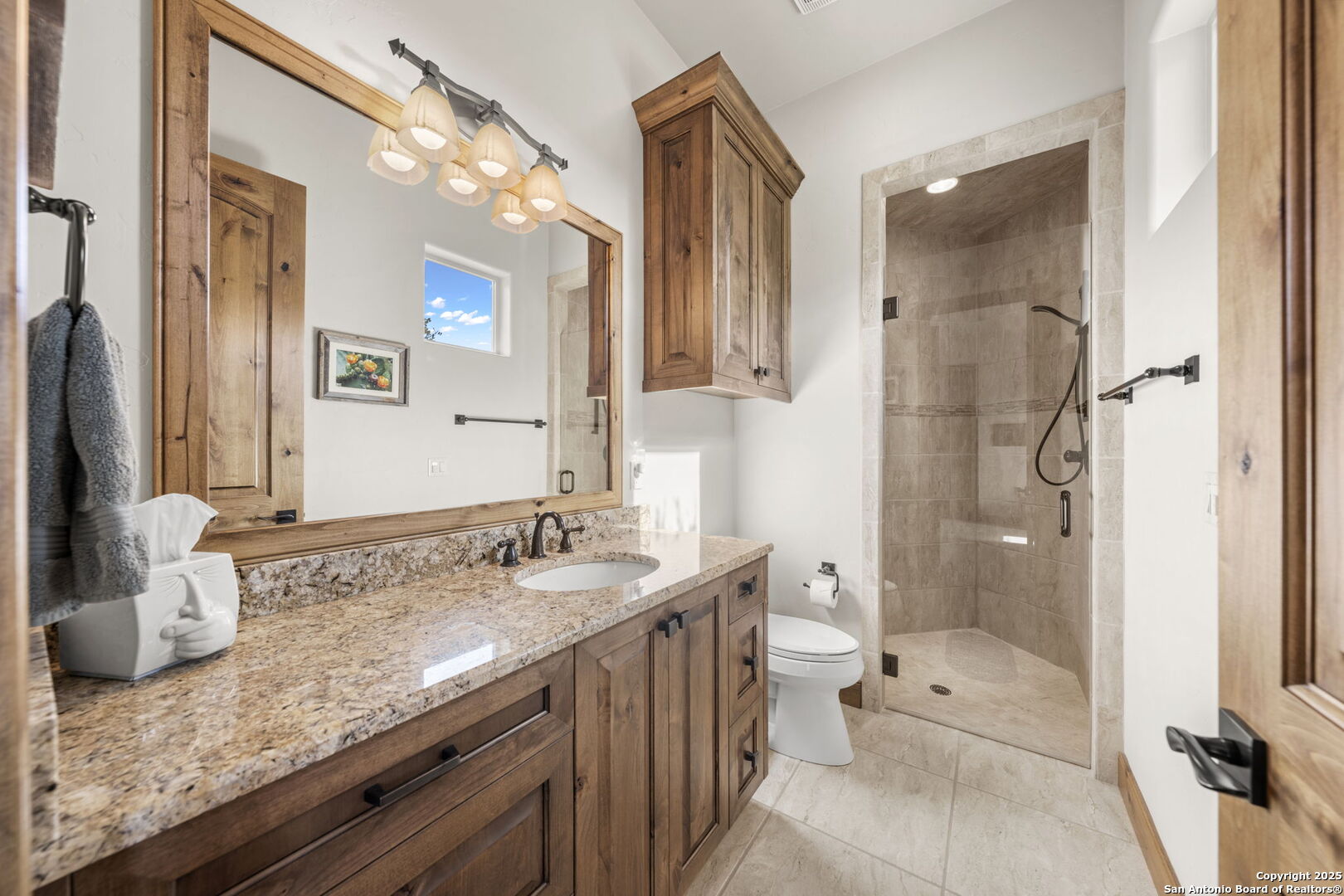 131 Bootlegger Lane North Kerrville, TX 78028 - Photo 27 of 50 a bathroom with a granite countertop sink a toilet a mirror and shower