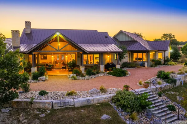 an aerial view of a residential houses with outdoor space and lake view