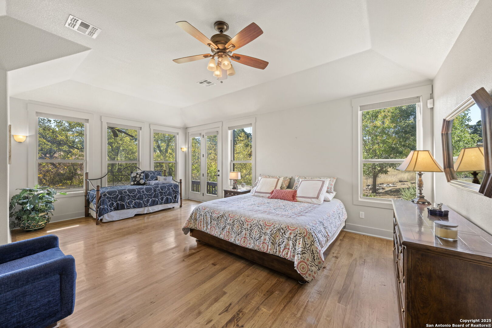 131 Bootlegger Lane North Kerrville, TX 78028 - Photo 41 of 50 a bedroom with a large bed and a chandelier