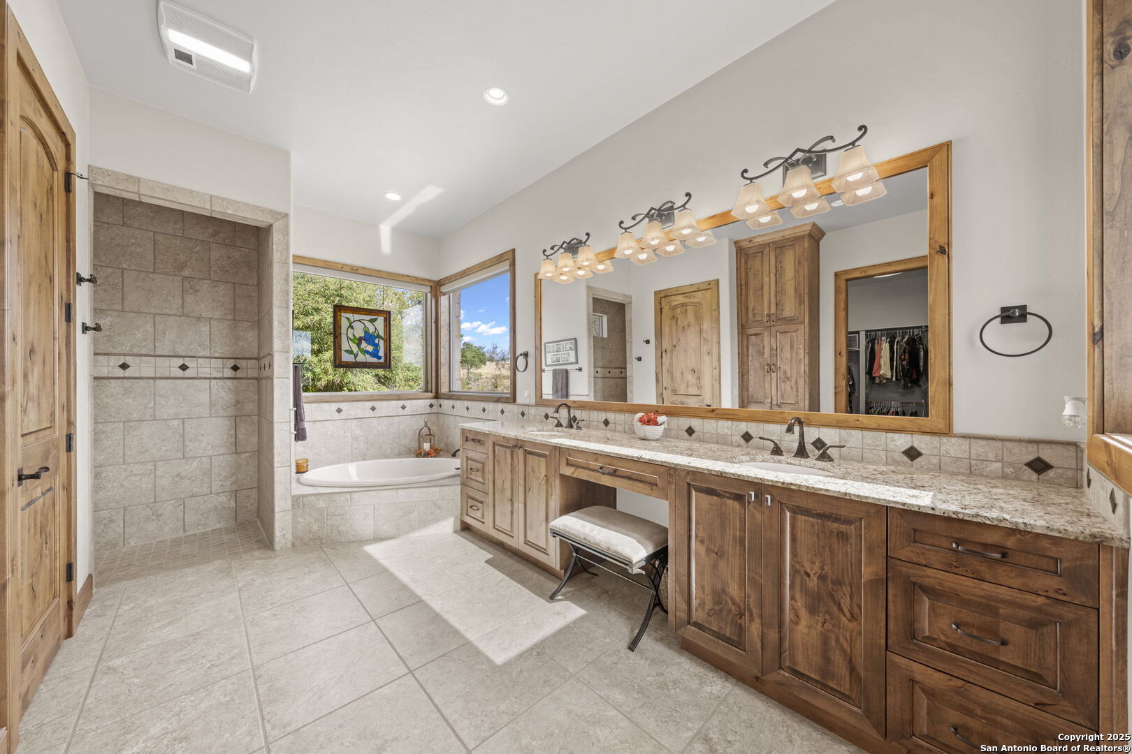 131 Bootlegger Lane North Kerrville, TX 78028 - Photo 8 of 50 a bathroom with a double vanity sink a large mirror and a bathtub