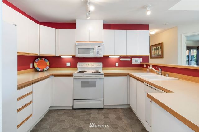 a kitchen with stainless steel appliances a sink stove and cabinets
