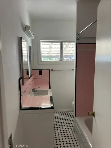 a bathroom with a sink toilet and window