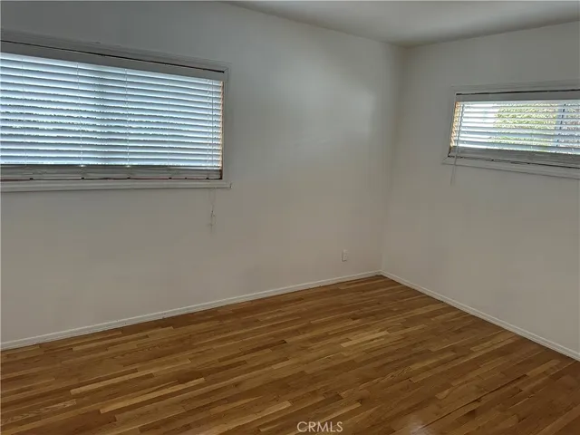 a view of a room that has wooden floor and a window