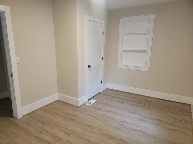 an empty room with wooden floor and closet