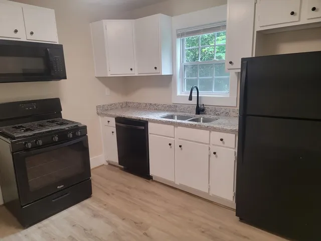 a kitchen with stainless steel appliances granite countertop a stove a refrigerator and a microwave