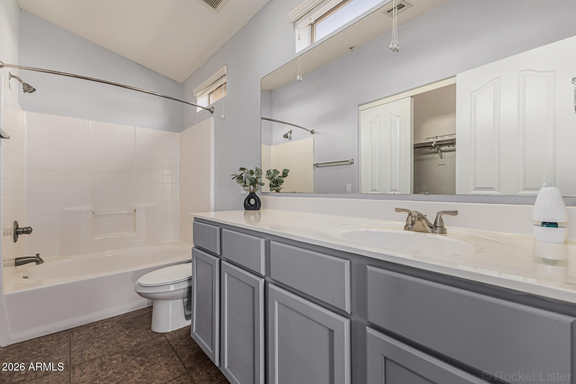 462 North 168th Lane Goodyear, AZ 85338 - Photo 12 of 32 a bathroom with a sink a toilet and a large mirror