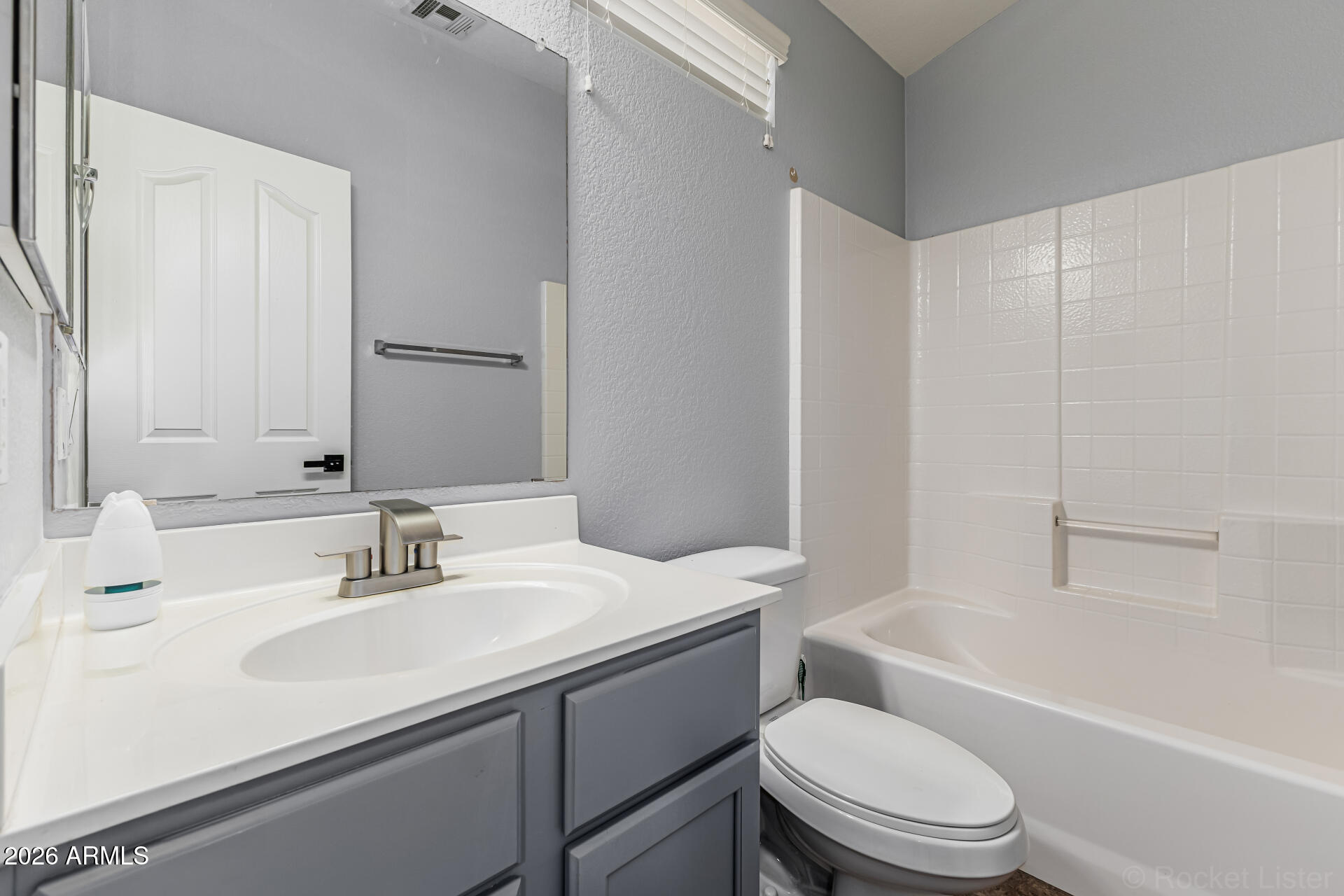 462 North 168th Lane Goodyear, AZ 85338 - Photo 16 of 32 a bathroom with a sink toilet vanity mirror and bathtub