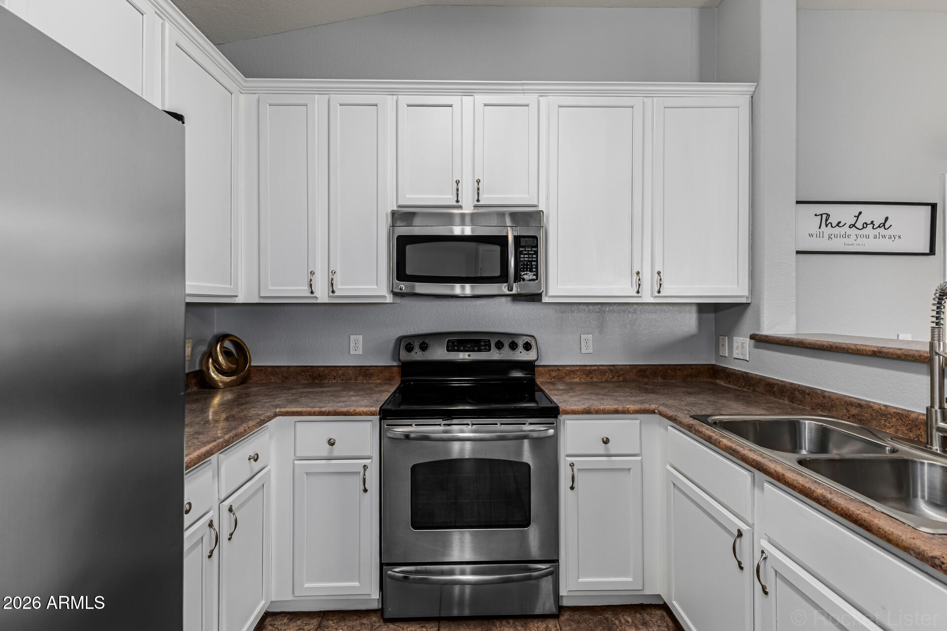 462 North 168th Lane Goodyear, AZ 85338 - Photo 7 of 32 a kitchen with granite countertop white cabinets and stainless steel appliances