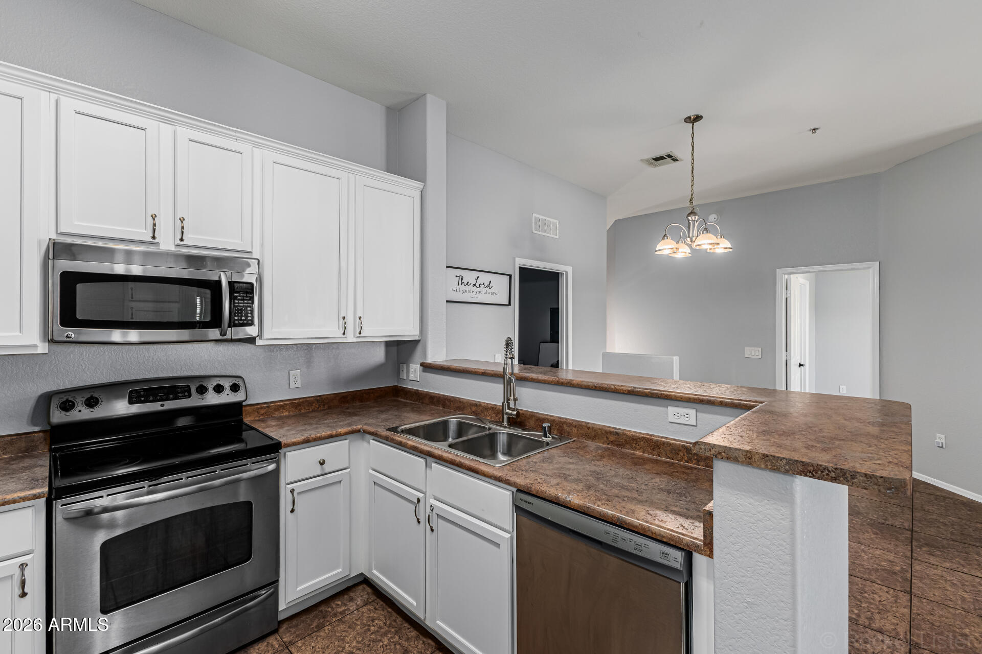462 North 168th Lane Goodyear, AZ 85338 - Photo 8 of 32 a kitchen with granite countertop a sink stainless steel appliances and white cabinets