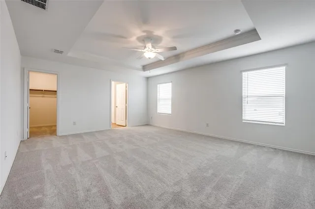 an empty room with windows and fan
