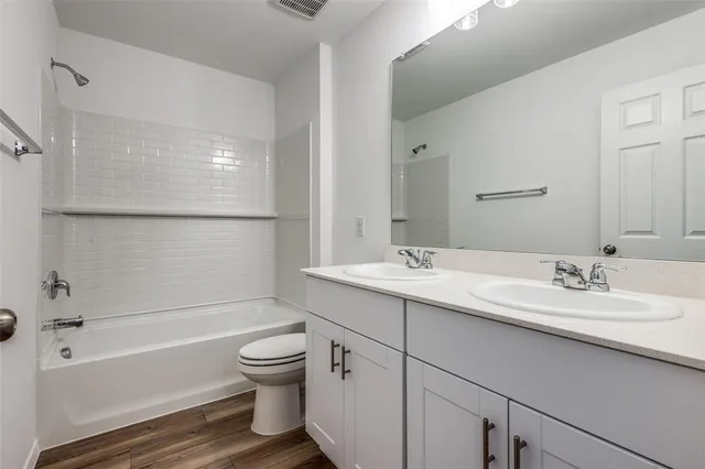 a bathroom with a granite countertop sink toilet and bathtub