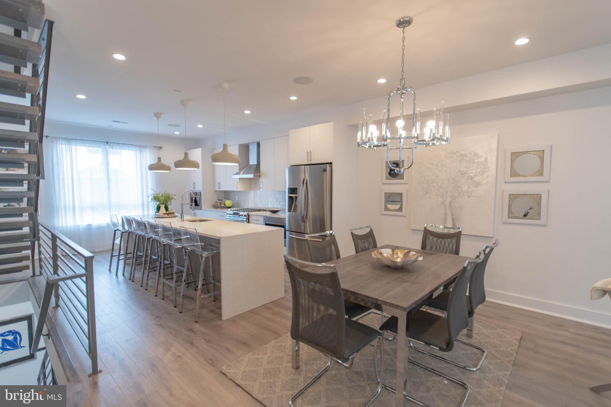 105 Olive Street Philadelphia, PA 19123 - Photo 11 of 36 a kitchen with kitchen island granite countertop a dining table chairs stainless steel appliances and cabinets