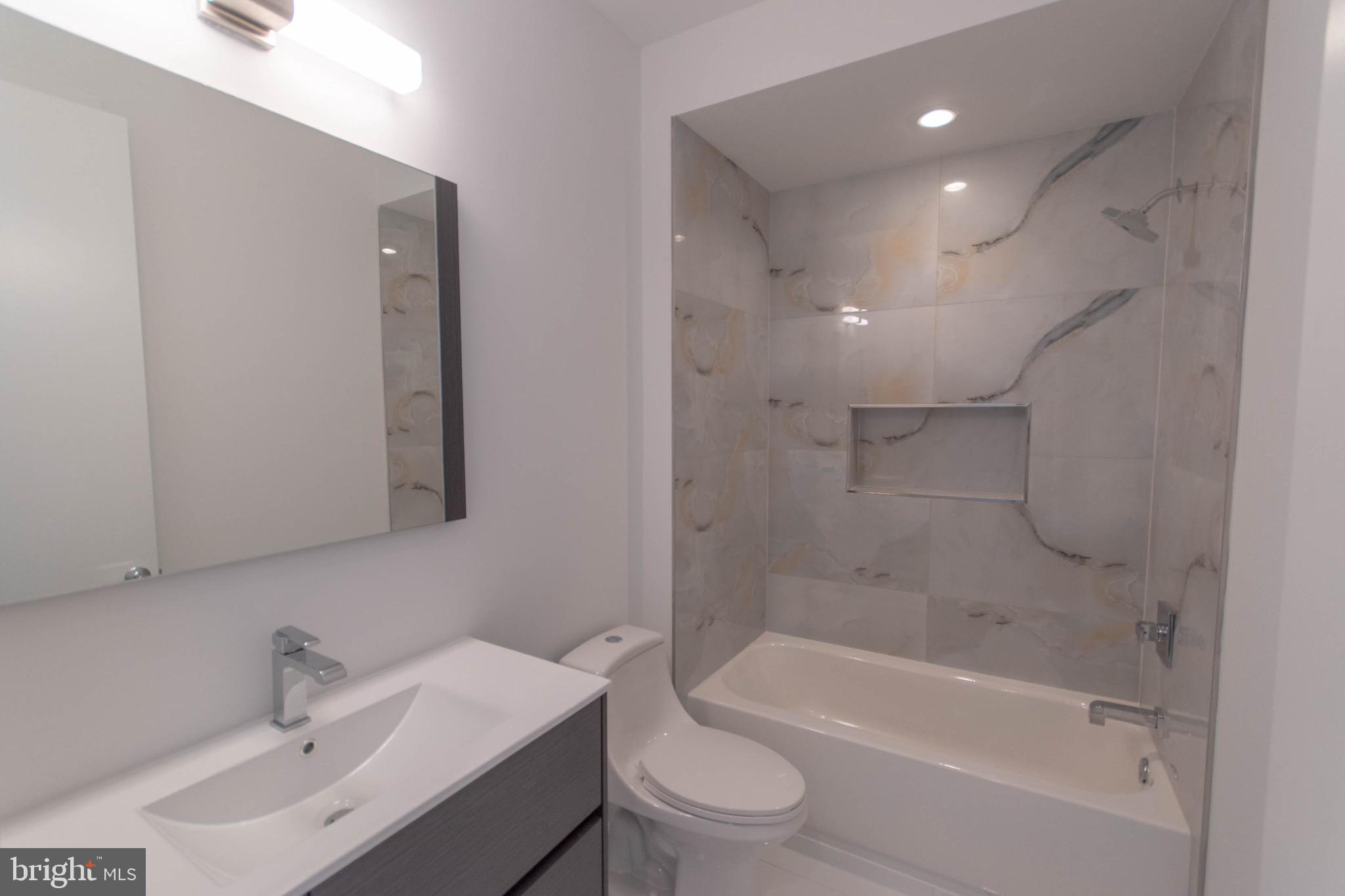 105 Olive Street Philadelphia, PA 19123 - Photo 16 of 36 a bathroom with a bathtub shower sink vanity mirror and toilet