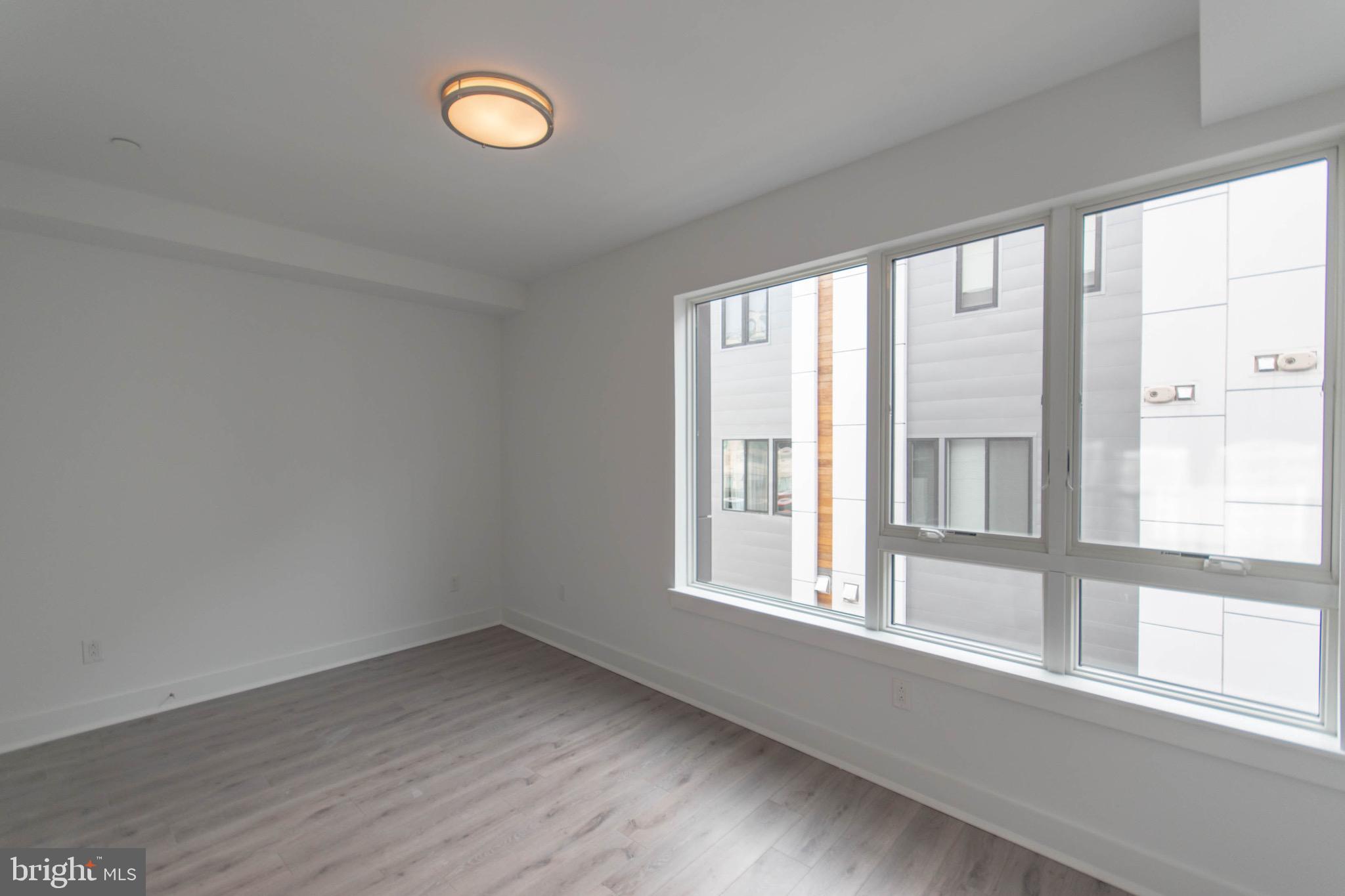 105 Olive Street Philadelphia, PA 19123 - Photo 17 of 36 a view of an empty room with wooden floor and a window