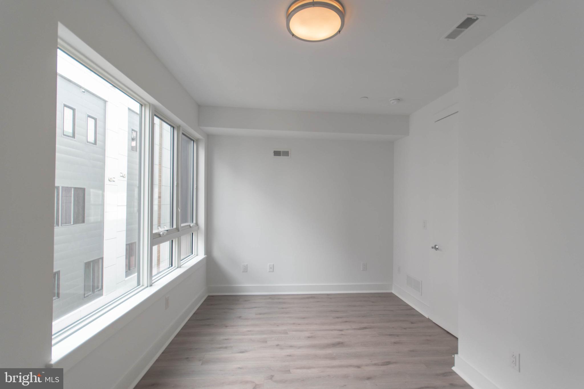 105 Olive Street Philadelphia, PA 19123 - Photo 18 of 36 a view of an empty room with wooden floor and a window