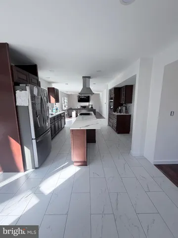 a kitchen with stainless steel appliances kitchen island granite countertop a refrigerator and a stove