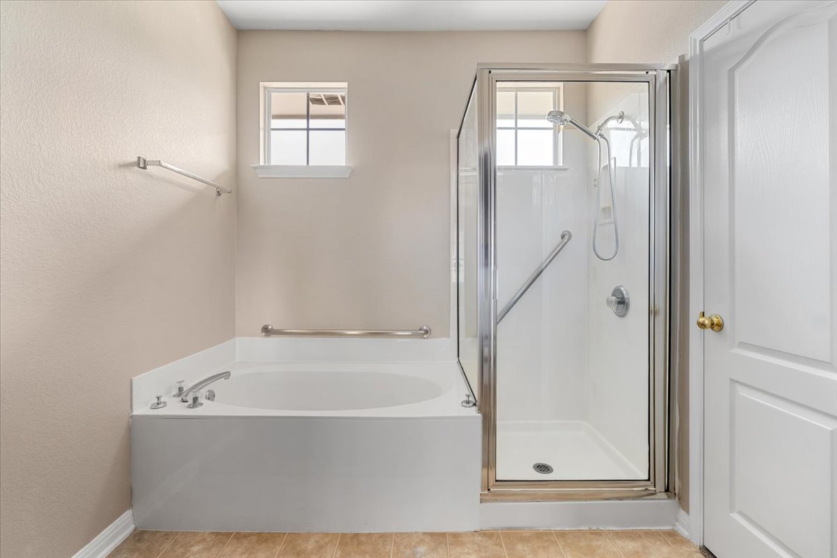 11000 Anderson Mill Road, Unit 11 Austin, TX 78750 - Photo 16 of 34 A deep soaking tub and a separate glass-enclosed shower create a serene bathing experience.