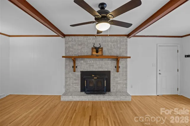 a view of empty room with wooden floor and fireplace
