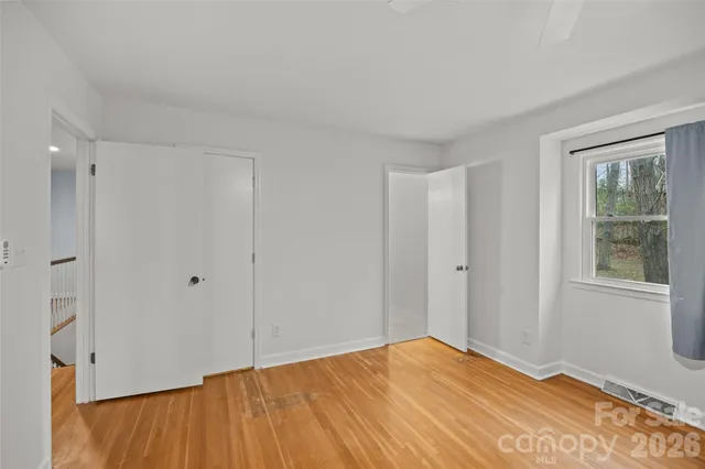a view of an empty room with wooden floor