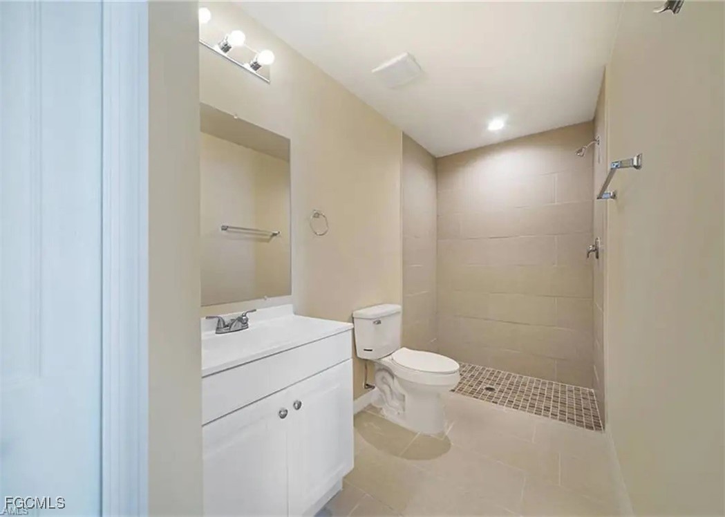 1114 Southwest 15th Place Cape Coral, FL 33991 - Photo 9 of 10 a bathroom with a sink a toilet a mirror and shower