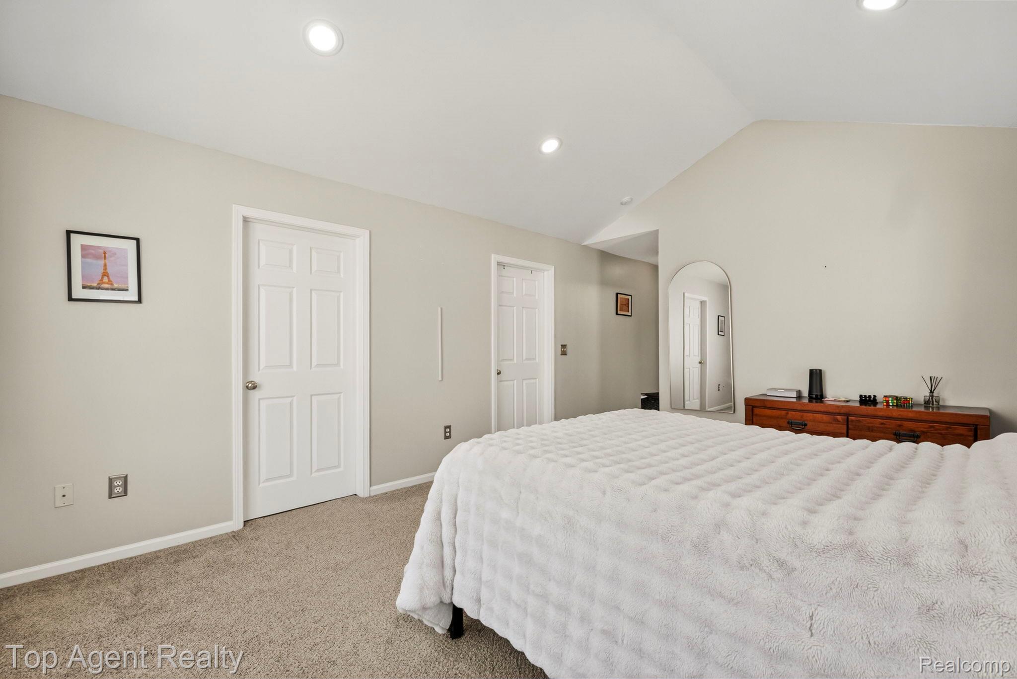 41567 Glade Road, Unit 20 Canton, MI 48187 - Photo 28 of 47 Bedroom featuring vaulted ceiling, light carpet, arched walkways, and recessed lighting