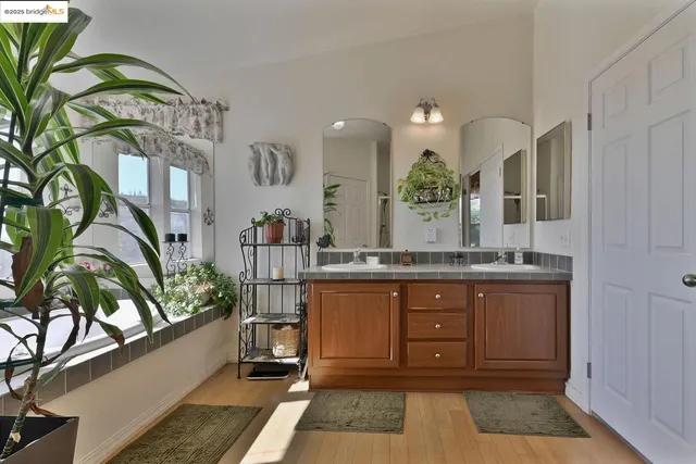 a bathroom with a double vanity sink toilet and a mirror