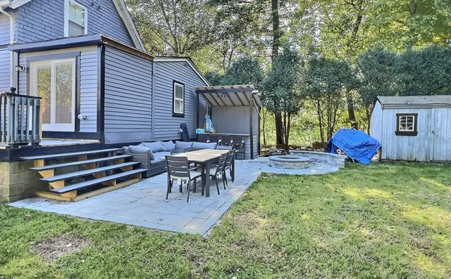 a view of a wooden bench sitting in backyard of house