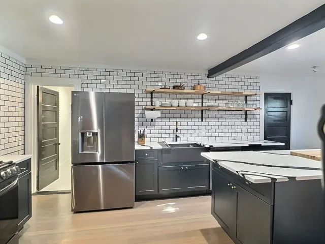 a kitchen with stainless steel appliances granite countertop a sink stove and refrigerator