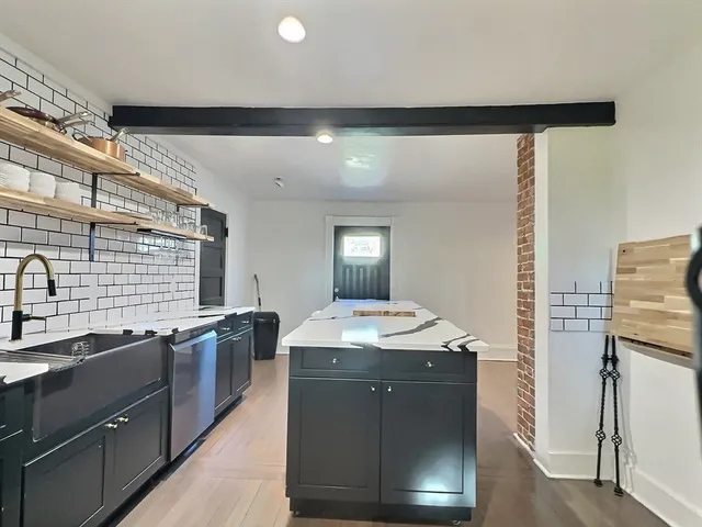 a kitchen with stainless steel appliances granite countertop a sink a stove and a refrigerator