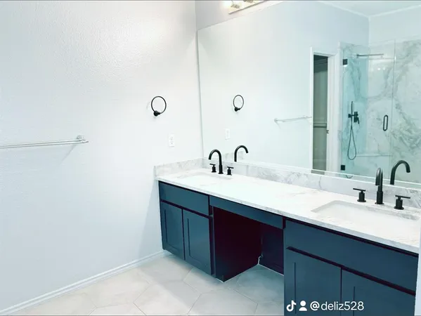 a bathroom with a double vanity sink and a mirror
