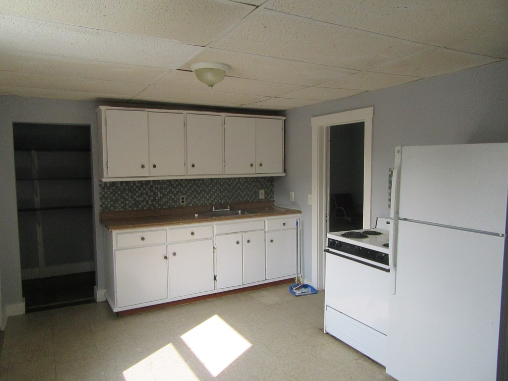 8-10 Stebbins Street Springfield, MA 01109 - Photo 2 of 9 a kitchen with granite countertop white cabinets and refrigerator