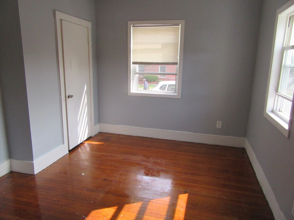 8-10 Stebbins Street Springfield, MA 01109 - Photo 5 of 9 an empty room with wooden floor and windows