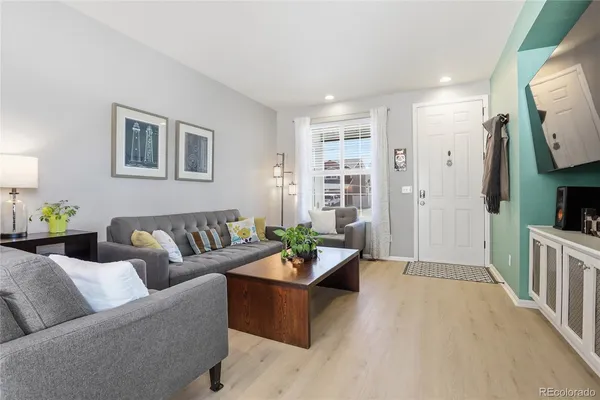 a living room with furniture a flat screen tv and a window